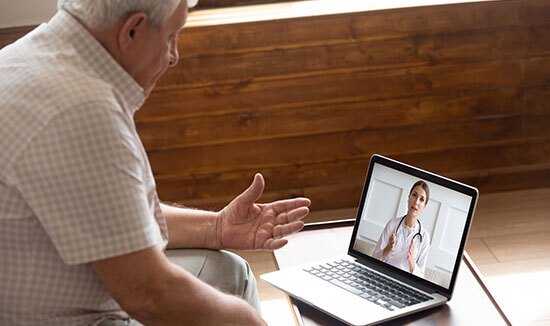 Older man consulting with female doctor during a video call
