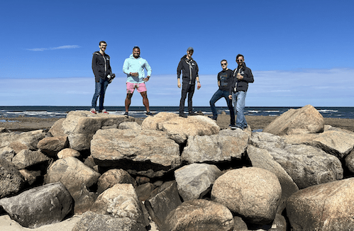 A group of five hikers standing on a pile of rocks